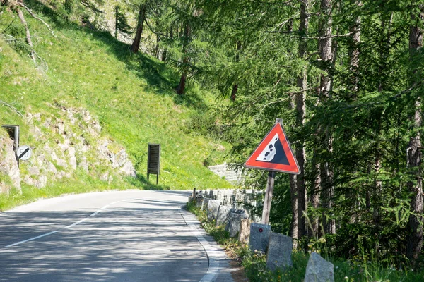 Road sign falling stones. Traffic sign caution possible falling rocks