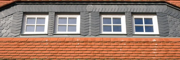 Červené a černé střešní dlaždice s windows — Stock fotografie
