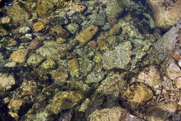 Křišťálově čistá voda s kameny — Stock fotografie