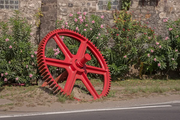 Engranaje rojo delante de una pared — Foto de Stock