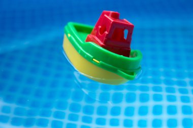 Küçük plastik oyuncak tekne bir yüzme havuzunda