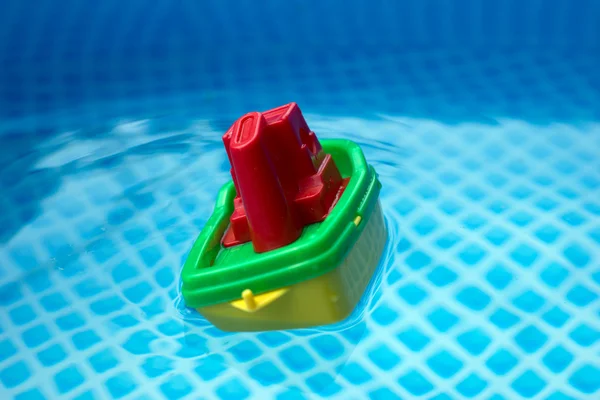 Pequeno barco de brinquedo de plástico em uma piscina — Fotografia de Stock