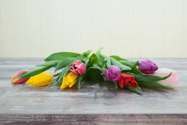 Friss színes tulipán virágok csokor a fából készült asztal — Stock Fotó