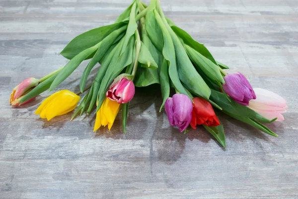 Verse kleurrijke tulp bloemen boeket op houten tafel — Stockfoto