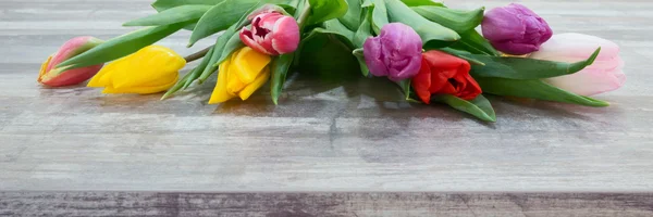 Verse kleurrijke tulp bloemen boeket op houten tafel — Stockfoto