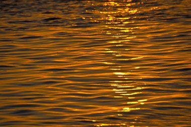 Gün batımında su yüzeyi arka