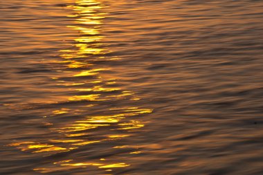 Gün batımında su yüzeyi arka