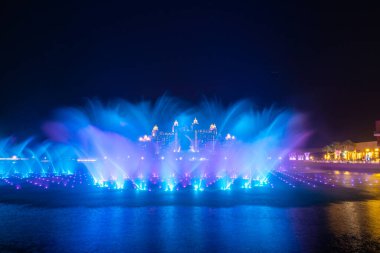 The Pointe Palm Jumeirah 'daki Şatafatlı Atlantis' in önündeki Palm Fountain Show 'a gece görüşü. Otel mavi saatte çekilmiş..