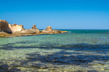 Deniz kıyısında ve sahilde kayalar, kayalık kıyı şeridi, mavi deniz, Yunanistan