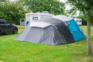 Kamp alanındaki çimlerin üzerinde mavi bir çadır