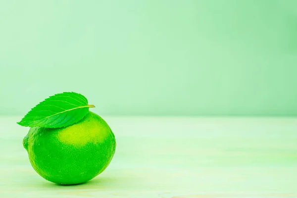 lemon and lime on green background with mint