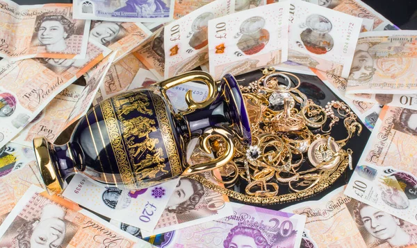 pile of gold money of united kingdom english pounds UK money on black background
