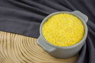 Mısır unu beyaz arkaplanda izole edilmiş bir kaba konur..