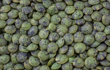 Ahşap arka planda bir kase yeşil Türk mercimeği