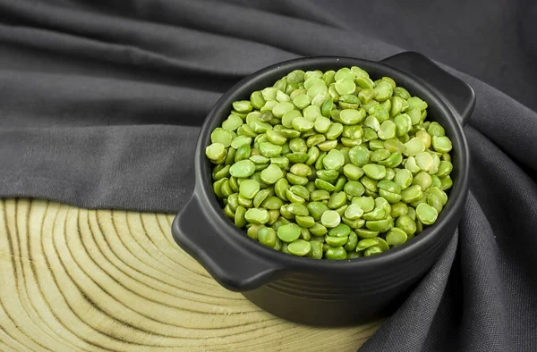 Dried green split peas in a ceramic bowl  on gray background.