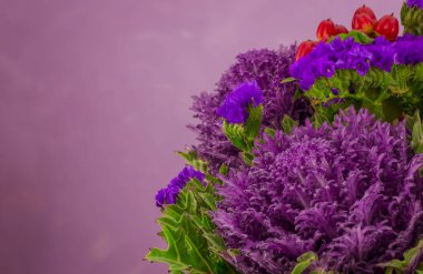 Farklı çiçeklerle süslenmiş güzel bir demet menekşe lahanası.