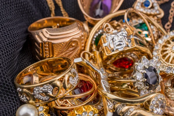 Pile of gold jewelry on black background