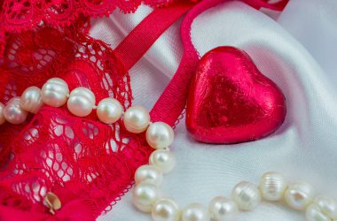 Beyaz arka planda kırmızı iç çamaşırı ve kırmızı kalp.