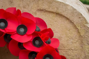 Kırmızı haşhaş çelenkleri Remem için bir savaş anıtının dibine bırakılmış.