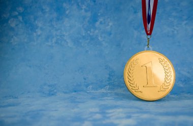 Arkaplanda kurdele olan altın madalya