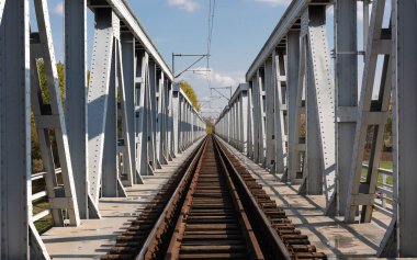 Demir köprü demiryolu bir bankayı diğerine bağlıyor.