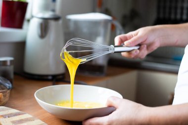 Yumurta çırpmak. Ekmek için malzemelerin hazırlanması. Ev yemeği..