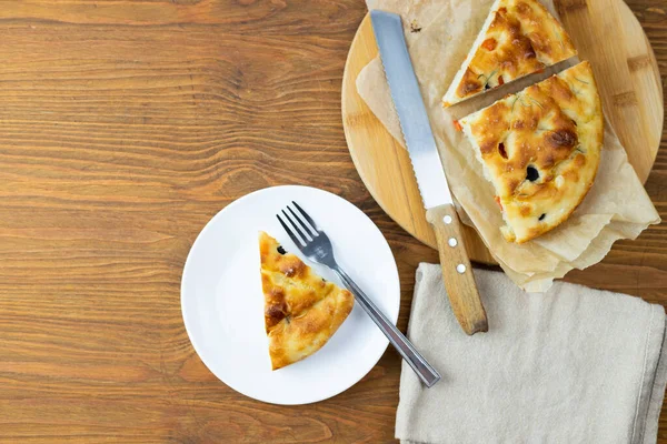 Focaccia, mutfak aksesuarlarıyla çevrili hazır bir İtalyan tabağı.