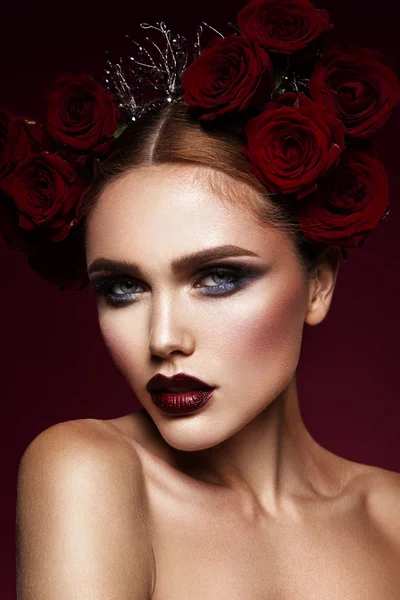 Menina modelo de moda de beleza com maquiagem escura e rosas em seu cabelo — Fotografia de Stock