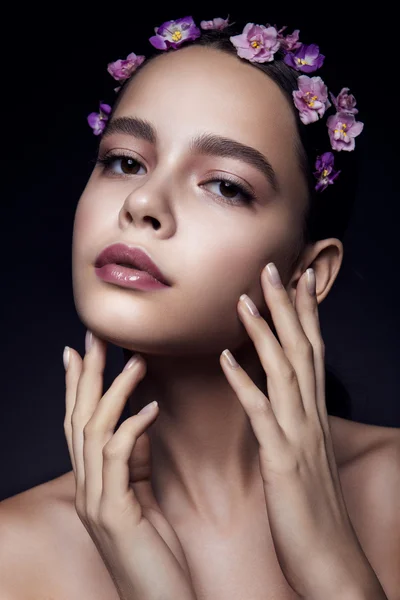 Mooi meisje met violette bloemen. — Stockfoto
