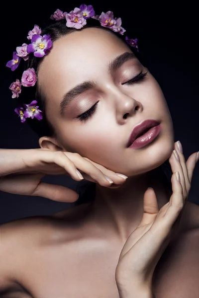 Menina bonita com flores violetas . — Fotografia de Stock