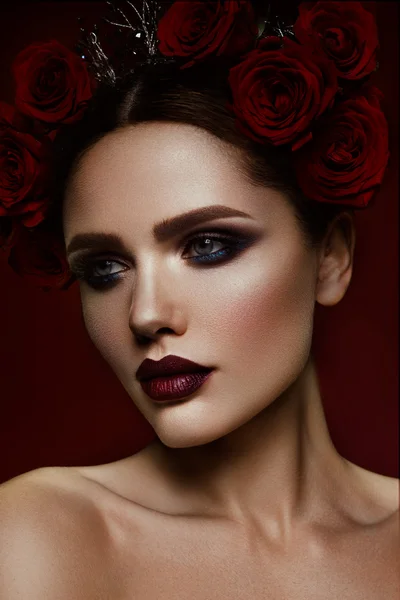 Menina modelo de moda de beleza com maquiagem escura e rosas em seu cabelo — Fotografia de Stock