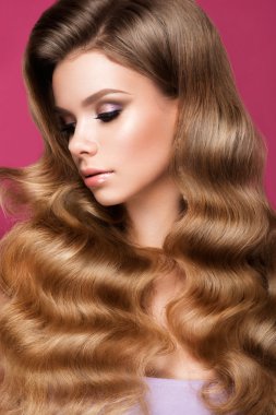 Uzun kıvırcık saçlı güzel bir genç kadın.