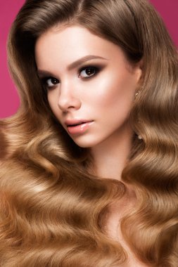 Uzun kıvırcık saçlı güzel bir genç kadın.