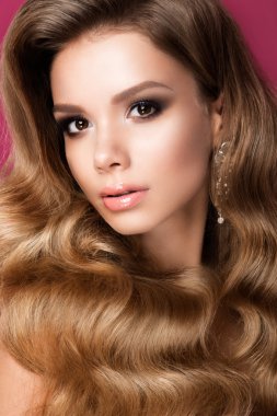 Uzun kıvırcık saçlı güzel bir genç kadın.