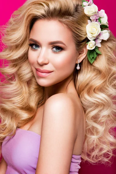 美丽的年轻女子假扮粉红闪亮背景上的长头发. — 图库照片