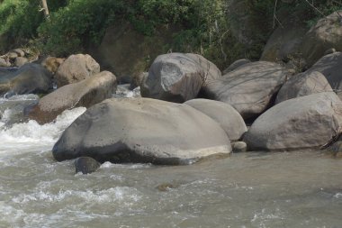 Nehirde doğal bir geçmişi olan büyük bir kaya.