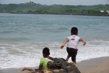 Blitar, Doğu Java, Endonezya - 7 Nisan 2020: İnsanlar Tambakrejo plajında tatil yapıyor