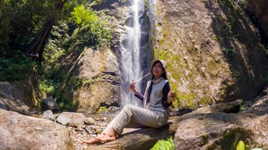 Dolo Şelalesi 'nde Asyalı kadın tatili. Doğu Java 'da güzel bir şelale