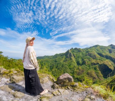 Beautiful Asian travelling to Kelud mountain in Indonesia. Mountain with blue sky background.