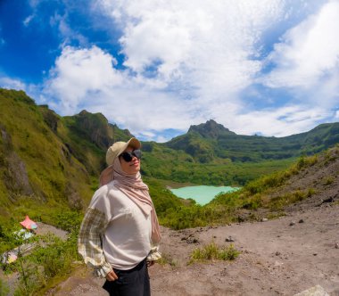 Beautiful Asian travelling to Kelud mountain in Indonesia. Mountain with blue sky background.