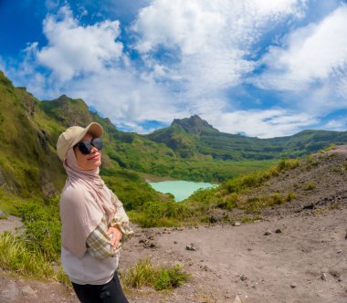 Beautiful Asian travelling to Kelud mountain in Indonesia. Mountain with blue sky background.