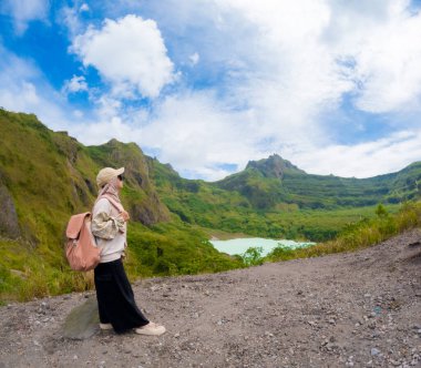Beautiful Asian travelling to Kelud mountain in Indonesia. Mountain with blue sky background.