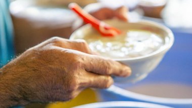 Satıcının elinde dawet (es cendol), Endonezya içeceği bulunur. Dawet, içinde yeşil pirinç unu jölesi, hindistan cevizi sütü ve palmiye şekeri şurubu bulunan buzlu tatlı bir tatlıdır..