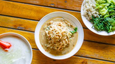 Pecel ve es dawet masada. Pecel fıstık soslu sebzedir. Es dawet hindistan cevizi sütü ve şeker soslu yeşil cendol damlası içerir..