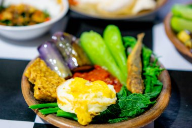 Kızarmış patlıcan, kızarmış tempeh, kızarmış tuzlu balık ve chayote ile bir toprak kapta Endonezya baharatı (sambal).