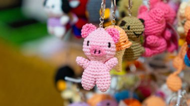 Sergide asılı duran pembe domuz anahtarlığı. Anahtarlığı çevir. Okul meselelerine dönelim..