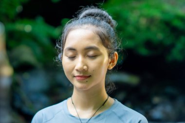 Doğada yoga yapan Asyalı bir kadın. Sağlıklı bir bedeni ve zihni korumak..