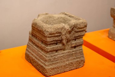 Masanın üzerinde bir taş var. Yoni taşı bir kadının doğurganlığını sembolize eder..