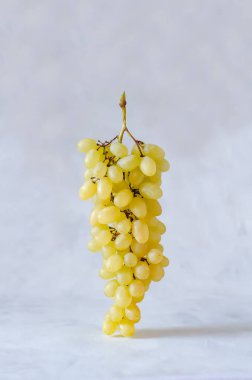 Taze taze organik üzümler havada süzülür, gri arka planda denge, sağlıklı beslenme ve yaşam tarzı