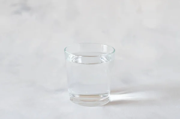 Glas reines Wasser auf dem grauen Hintergrund. Kopierraum. — Stockfoto